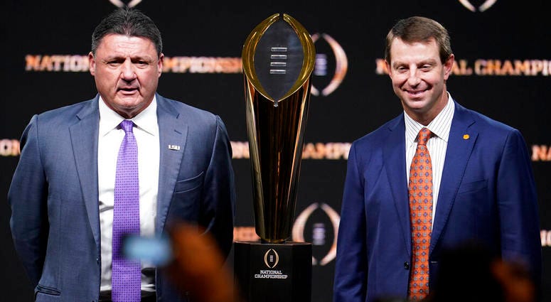 LSU head coach Ed Orgeron, left, and Clemson head coach Dabo Swinney pose with the trophy after a news conference for the NCAA College Football Playoff national championship game Sunday, Jan. 12, 2020, in New Orleans. Clemson is scheduled to play LSU on M