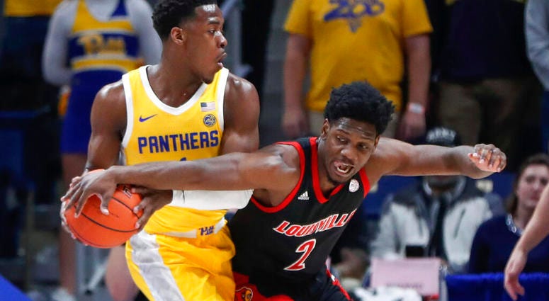 Louisville's Darius Perry (2) reaches for the ball held by Pittsburgh's Xavier Johnson during the first half of an NCAA college basketball game Tuesday, Jan. 14, 2020, in Pittsburgh.