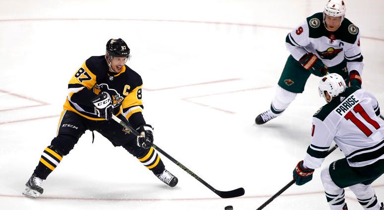 Pittsburgh Penguins' Sidney Crosby (87) gets off a pass with Minnesota Wild's Zach Parise (11) and Mikko Koivu (9) defending during the first period of an NHL hockey game in Pittsburgh, Tuesday, Jan. 14, 2020. AP DO NOT USE