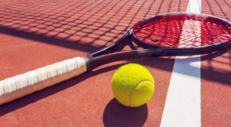 Tennis balls and racket on the grass court
