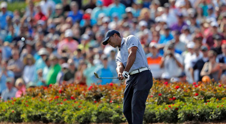 Tiger Woods hits from the drop zone after hitting his tee shot into the water on the 17th hole during the second round of The Players Championship golf tournament Friday, March 15, 2019, in Ponte Vedra Beach, Fla Tiger Woods hits from the drop zone after hitting his tee shot into the water on the 17th hole during the second round of The Players Championship golf tournament Friday, March 15, 2019, in Ponte Vedra Beach, Fla