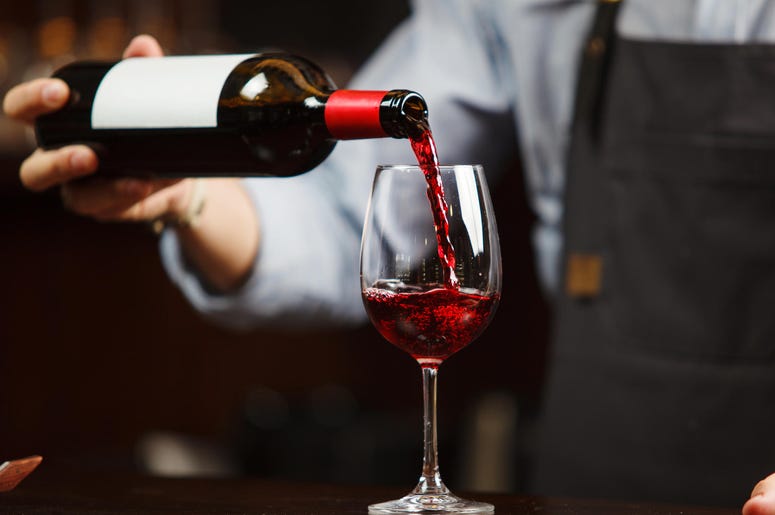 Waiter pouring red wine into wineglass. Waiter pouring red wine into wineglass.
