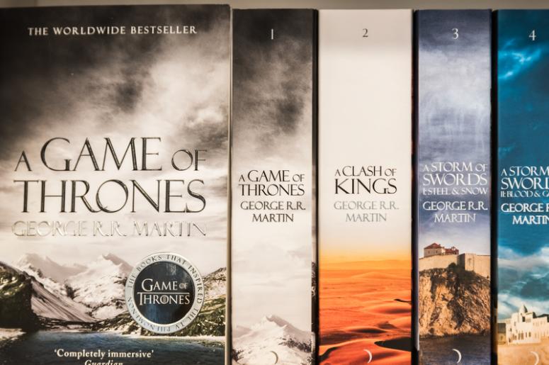 BUCHAREST, ROMANIA - MARCH 07, 2015: Game Of Thrones Books For Sale On Library Shelf. It is the first novel in a series of high fantasy novels by American author George R. R. Martin. BUCHAREST, ROMANIA - MARCH 07, 2015: Game Of Thrones Books For Sale On Library Shelf. It is the first novel in a series of high fantasy novels by American author George R. R. Martin.