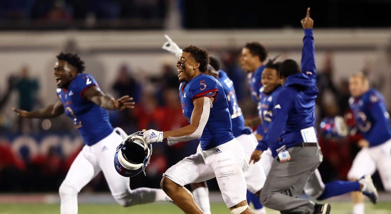 Wide receiver Stephon Robinson Jr. #5 and the Kansas Jayhawks storm the field and celebrate as they defeat the Texas Tech Red Raiders 37-34 to win the game at Memorial Stadium on October 26, 2019 in Lawrence, Kansas.