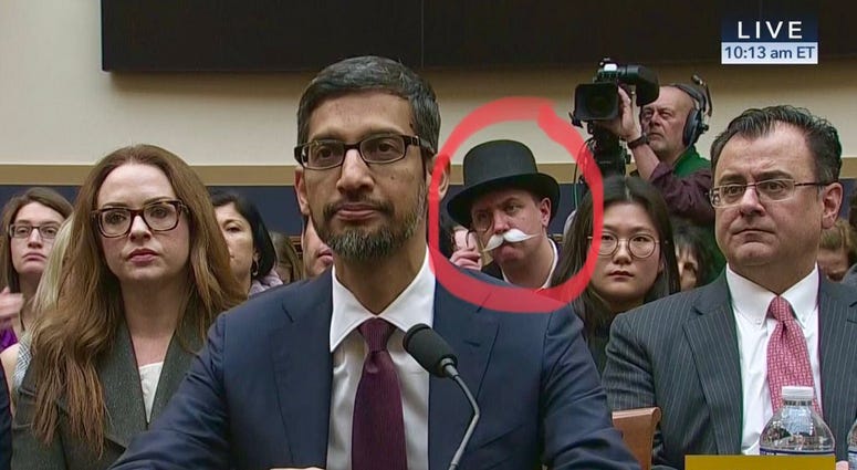 Monopoly man appears in back of congressional hearing. Monopoly man appears in back of congressional hearing.