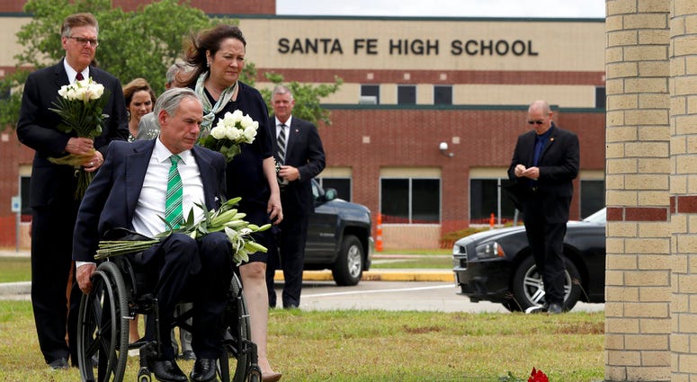 Gov. Greg Abbott, his wife, Cecilia, Lt. Gov. Dan Patrick, along with Sen. Larry Taylor and Rep. Greg Bonnen prepare to place flowers Sunday, May 20, 2018, at Santa Fe High School.