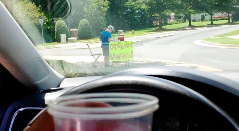 This Saturday, Aug. 4 2018, photo provided by James Castellano, of Monroe, N.C., shows a drink he bought from a boy, background, in Monroe