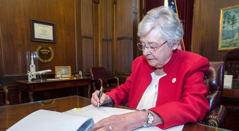 Alabama Gov. Kay Ivey signing a bill that virtually outlaws abortion in the state, in Montgomery, Ala.