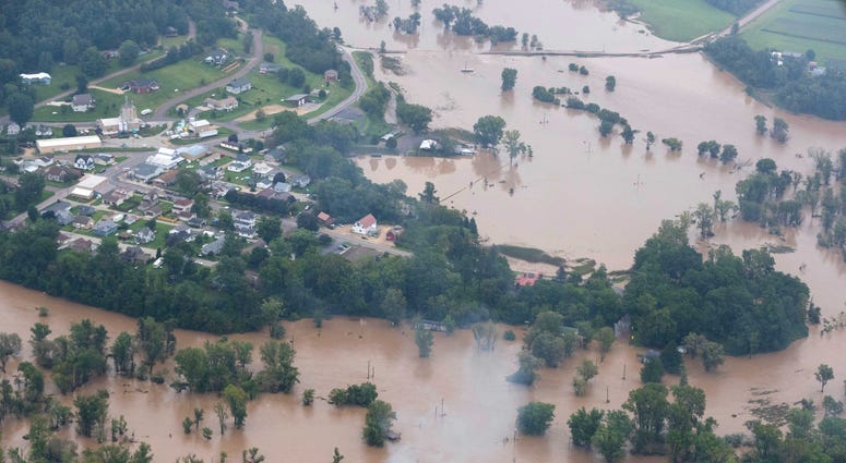 A trailer home smolders (foreground) while floodwaters cover a large area in the Vernon County municipality of Chaseburg, Wis. A trailer home smolders (foreground) while floodwaters cover a large area in the Vernon County municipality of Chaseburg, Wis.