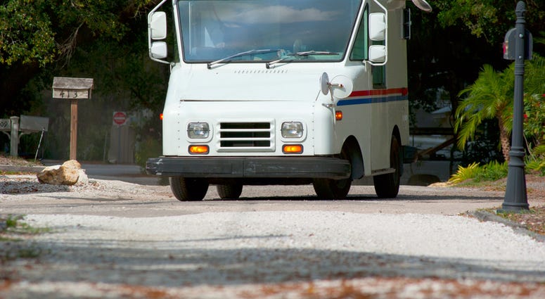 Mail delivery truck on a residential road on a sunny day