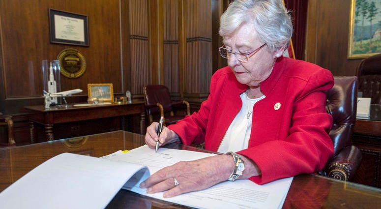 Alabama Gov. Kay Ivey signing a bill that virtually outlaws abortion in the state, in Montgomery, Ala.