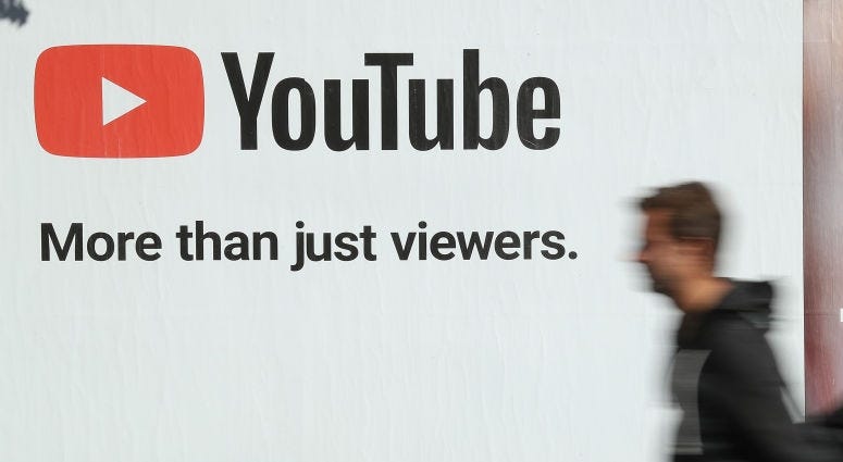 man walking past youtube sign