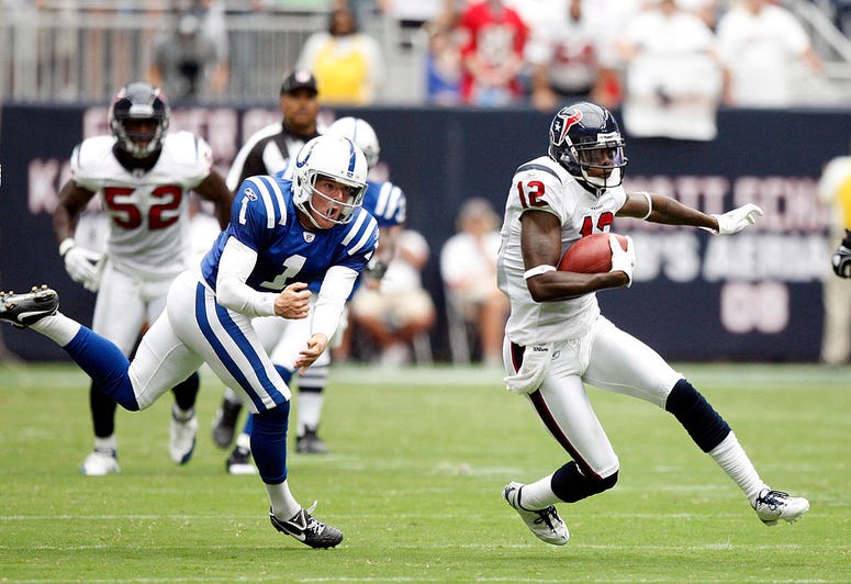 Jacoby Jones #12 of the Houston Texans avoids kicker Pat McAfee #1 of the Indianapolis Colts on the opening kick return during the NFL season opener at Reliant Stadium on September 12, 2010 in Houston, Texas.