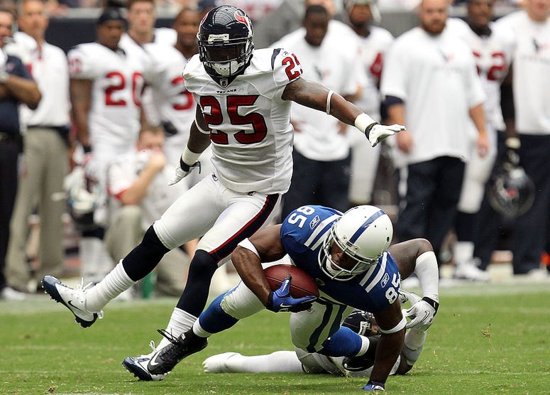 Wide receiver Pierre Garcon #85 of the Indianapolis Colts runs the ball against Zac Diles #54 and Kareem Jackson #25 of the Houston Texans during the NFL season opener at Reliant Stadium on September 12, 2010 in Houston, Texas.