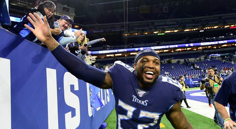 Tennessee Titans running back Derrick Henry (22) celebrates with fans after the Titans beat the Colts , 31-17, at Lucas Oil Stadium.
