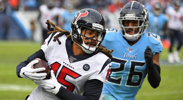Houston Texans wide receiver Will Fuller (15) catches a pass past coverage fro Tennessee Titans cornerback Logan Ryan (26) during the second half at Nissan Stadium.