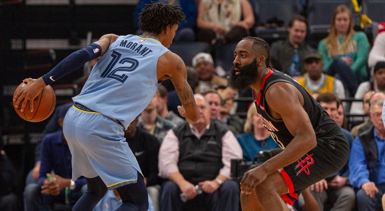 Memphis Grizzlies guard Ja Morant (12) handles the ball against Houston Rockets guard James Harden (13) during the first half at FedExForum.