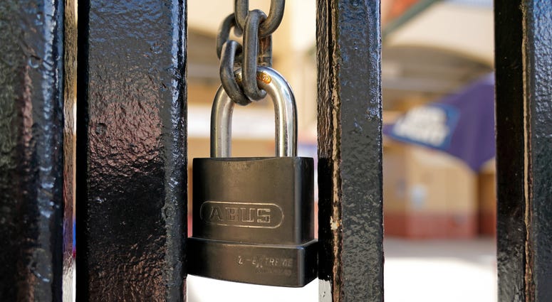 A padlock is seen on the gate of the entrance of Roger Dean Chevrolet Stadium. Major League Baseball has suspended the rest of its spring training schedule due to the Covid 19 coronavirus outbreak.