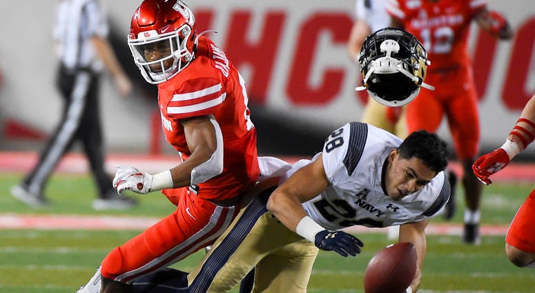 Navy wide receiver Keoni-Kordell Makekau, right, is hit by Houston cornerback Damarion Williams during the second half of an NCAA college football game, Saturday, Nov. 30, 2019, in Houston.