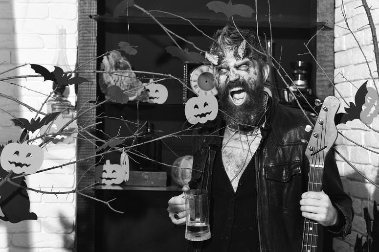 Halloween decor on background Demon with horns and wild face holds black electric guitar. Halloween decor on background Demon with horns and wild face holds black electric guitar.