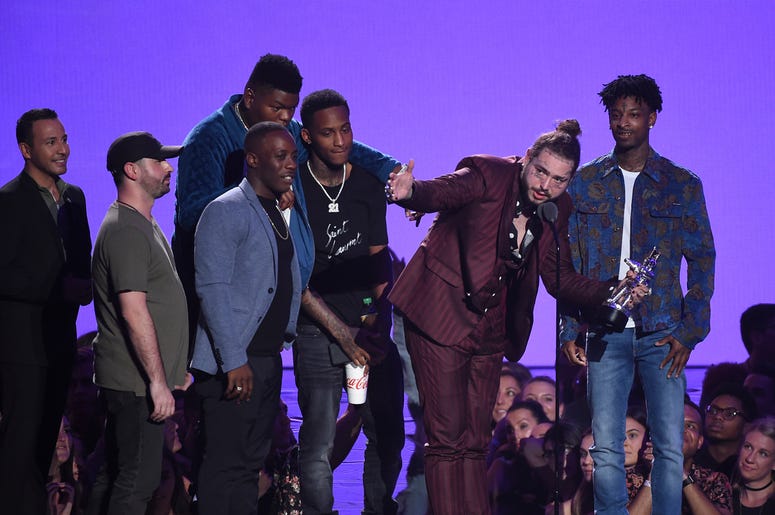 Post Malone and his entourage NEW YORK CITY - AUGUST 20: Post Malone, recipient of the award for Song of the Year, and 21 Savage speak onstage during the 2018 MTV Video Music Awards at Radio City Music Hall on August 20, 2018 in New York City. (Photo by Frank Micelotta/PictureGroup/Si