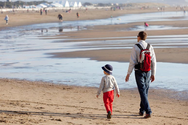 Family of father and his son walking together at the beach in California. Family of father and his son walking together at the beach in California. (Photo credit: Getty Images)