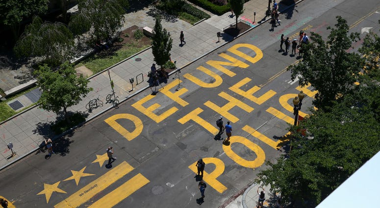 defund the police painted on a city street