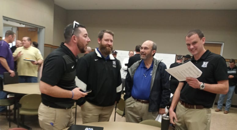 The assistant coaches at Vandegrift and Cedar Park meet up during the UIL Redistricting announcements