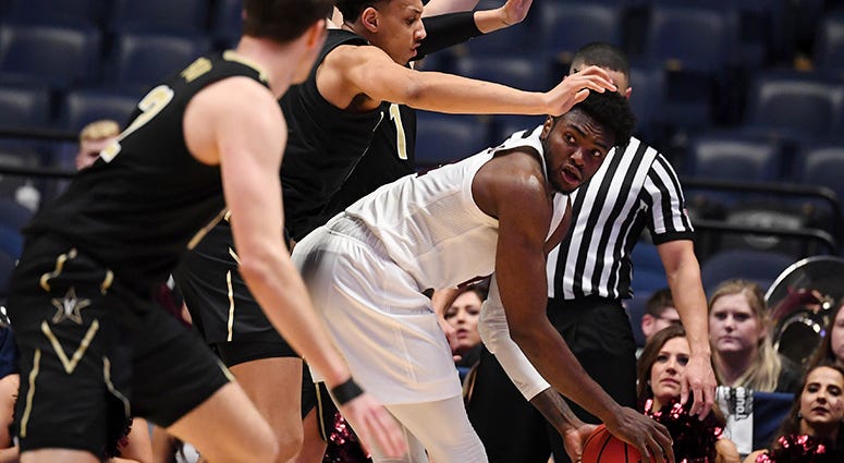 Texas A&M Aggies forward Christian Mekowulu (21) looks to pass the ball as he is defended by Vanderbilt Commodores players during the second half of the SEC conference tournament at Bridgestone Arena. Texas A&M Aggies forward Christian Mekowulu (21) looks to pass the ball as he is defended by Vanderbilt Commodores players during the second half of the SEC conference tournament at Bridgestone Arena.