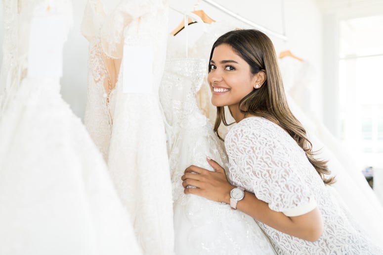 Woman selecting bridal gown Woman selecting bridal gown
