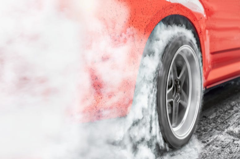 Racing car burns rubber off its tires Racing car burns rubber off its tires