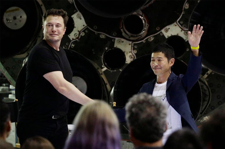 AP18261097654026 SpaceX founder and chief executive Elon Musk, left, shakes hands with Japanese billionaire Yusaku Maezawa, right, after announcing him as the first private passenger on a trip around the moon, Monday, Sept. 17, 2018, in Hawthorne, Calif. (AP Photo/Chris C
