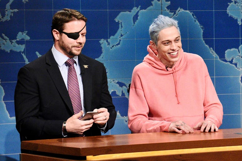 AP18315564956090 In this Nov. 10, 2018 photo provided by NBC, Lt. Com. Dan Crenshaw, from left, a congressman-elect from Texas and Pete Davidson appear during Saturday Night Live’s "Weekend Update" in New York. Davidson made his apologies to Crenshaw whose appearance he m