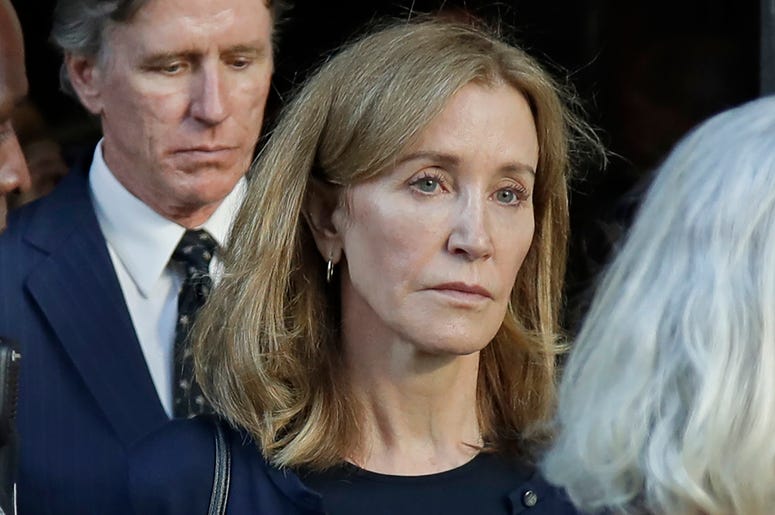 AP19256735150823 Actress Felicity Huffman leaves federal court accompanied by her brother, Moore Huffman Jr., center, after her sentencing in a nationwide college admissions bribery scandal, Friday, Sept. 13, 2019, in Boston. (AP Photo/Elise Amendola)
