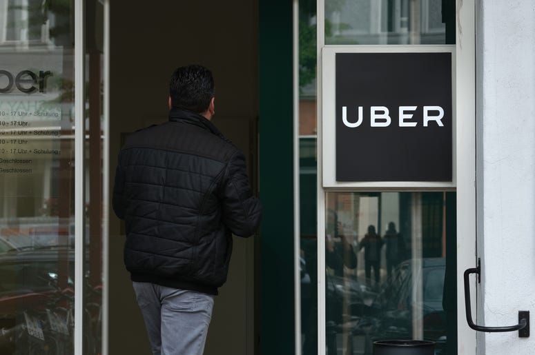 (Sean Gallup/ Getty Images) A man enters an Uber drivers registration office.