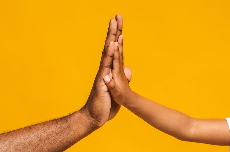 (Prostock-Studio/ iStock/ Getty Images Plus) High five gesture of black father and child