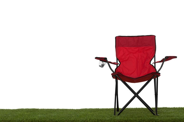 (ohmygouche/ iStock/ Getty Images Plus) Folding camp chair front view on grass with white background