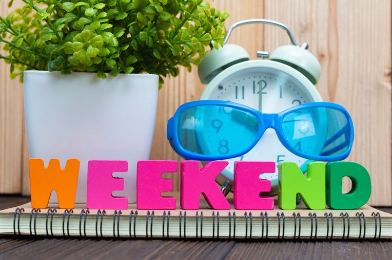 WEEKEND letters text and notebook paper, alarm clock and little WEEKEND letters text and notebook paper, alarm clock and little