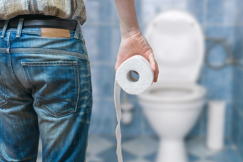 Man suffers from diarrhea holds toilet paper roll in front of toilet bowl. Man suffers from diarrhea holds toilet paper roll in front of toilet bowl.