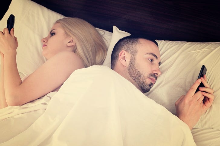 Couple socializing with mobile phones in bed Couple socializing with mobile phones in bed