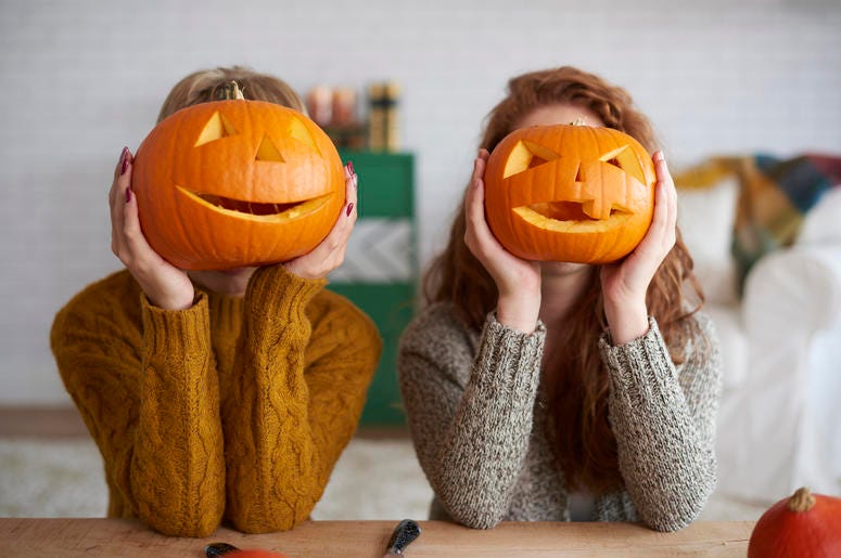 (gpointstudios/ iStock/ Getty Images Plus) Two women showing Halloween pumpkins