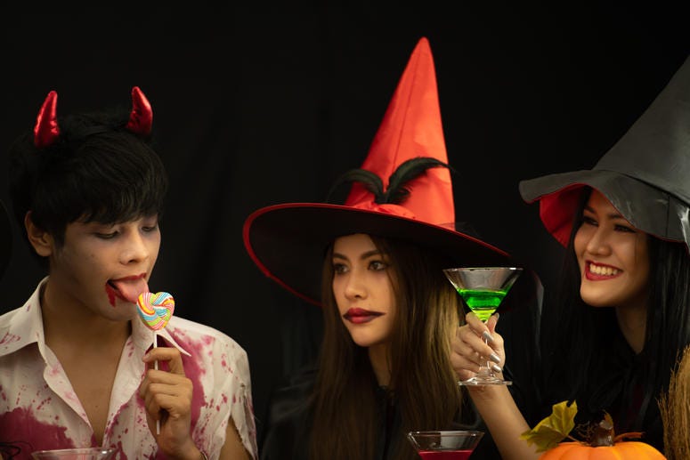 (Sunan Wongsa-Nga/ iStock/ Getty Images Plus) Two witches and a guy licking lollipop