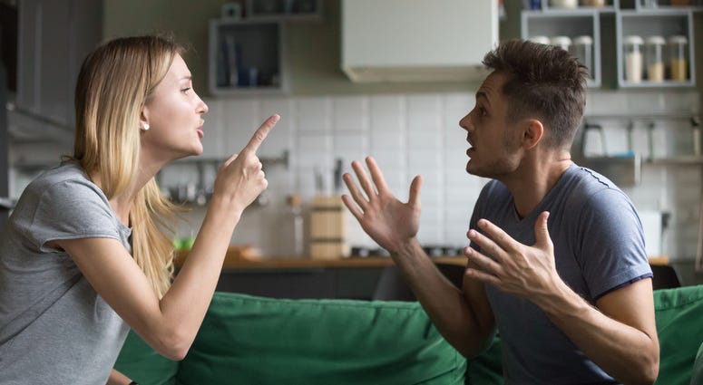 couple sitting on couch arguing