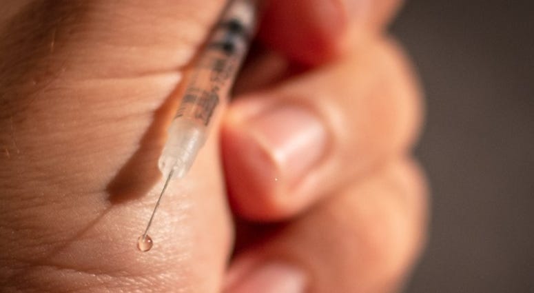 Close-up image of hypodermic needle in person's hand