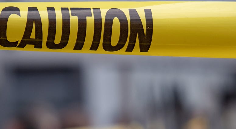 Yellow caution tape is stretched across the site of an emergency.