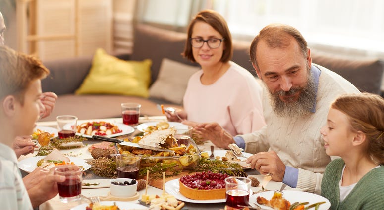 A happy family enjoys Thanksgiving dinner.