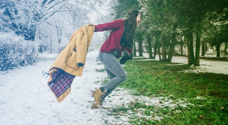 Woman sheds winter coat as spring approaches