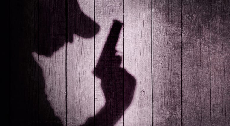 Shadow of a man holding a handgun
