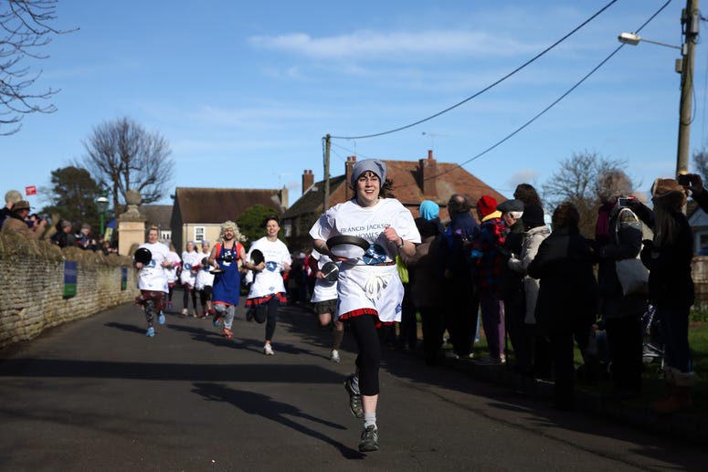 OLNEY, ENGLAND - FEBRUARY 09: Competitors take part in the annual Shrove Tuesday trans-Atlantic pancake race on February 9, 2016 in Olney, England. On Shrove Tuesday every year the ladies of Olney, Buckinghamshire compete in a Pancake Race, a tradition wh OLNEY, ENGLAND - FEBRUARY 09: Competitors take part in the annual Shrove Tuesday trans-Atlantic pancake race on February 9, 2016 in Olney, England. On Shrove Tuesday every year the ladies of Olney, Buckinghamshire compete in a Pancake Race, a tradition wh