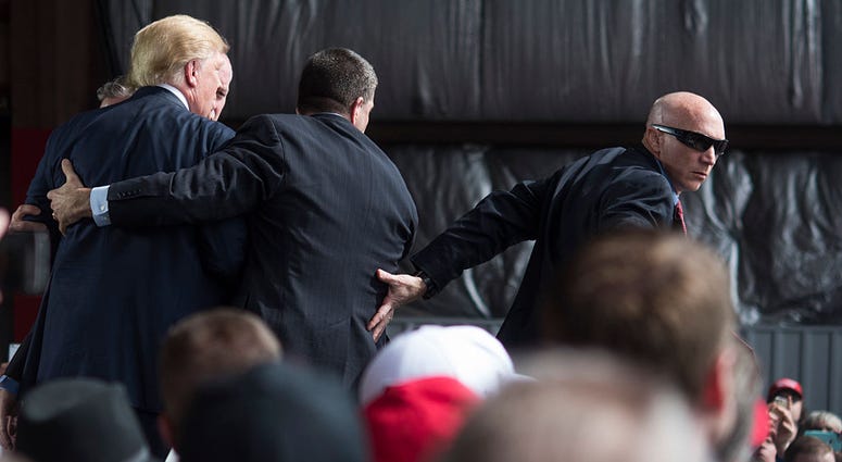 VANDALIA, OH - MARCH 12: Secret Service swarms around Republican Presidential candidate Donald Trump after a bottle was thrown on stage at a Campaign Rally on March 12, 2016 in Vandailia, Ohio. VANDALIA, OH - MARCH 12: Secret Service swarms around Republican Presidential candidate Donald Trump after a bottle was thrown on stage at a Campaign Rally on March 12, 2016 in Vandailia, Ohio.